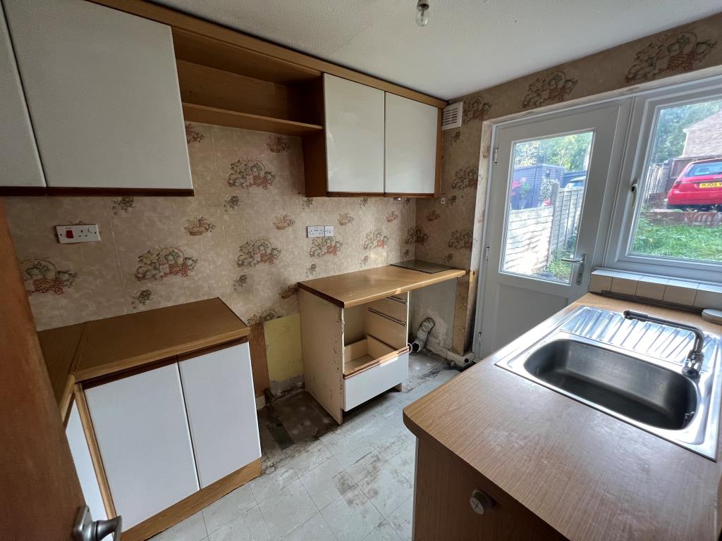 Lot: 23 - THREE-BEDROOM HOUSE FOR IMPROVEMENT - Kitchen looking out to garden and off road parking space